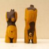 Stylized wooden sculptures of the female torso, blending abstraction and femininity in art.