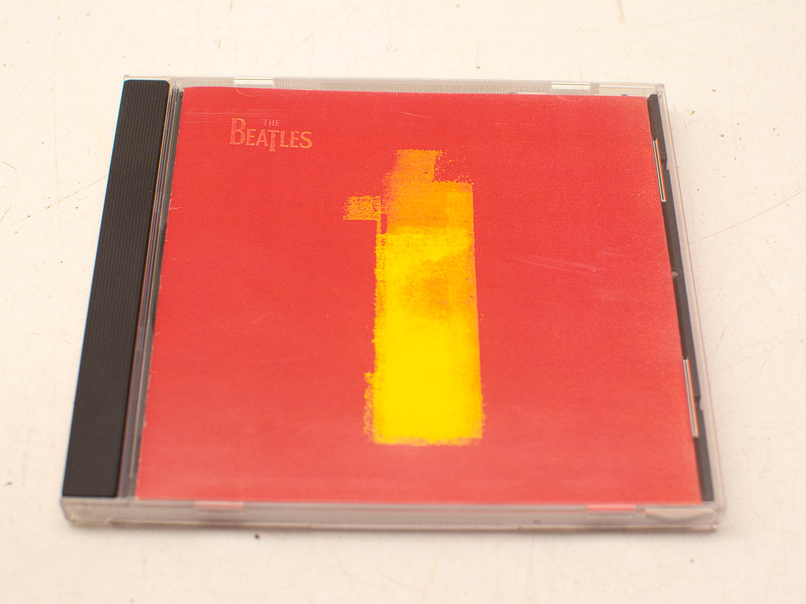 The Beatles compilation album 1 featuring iconic hits in a minimalist red and yellow design.