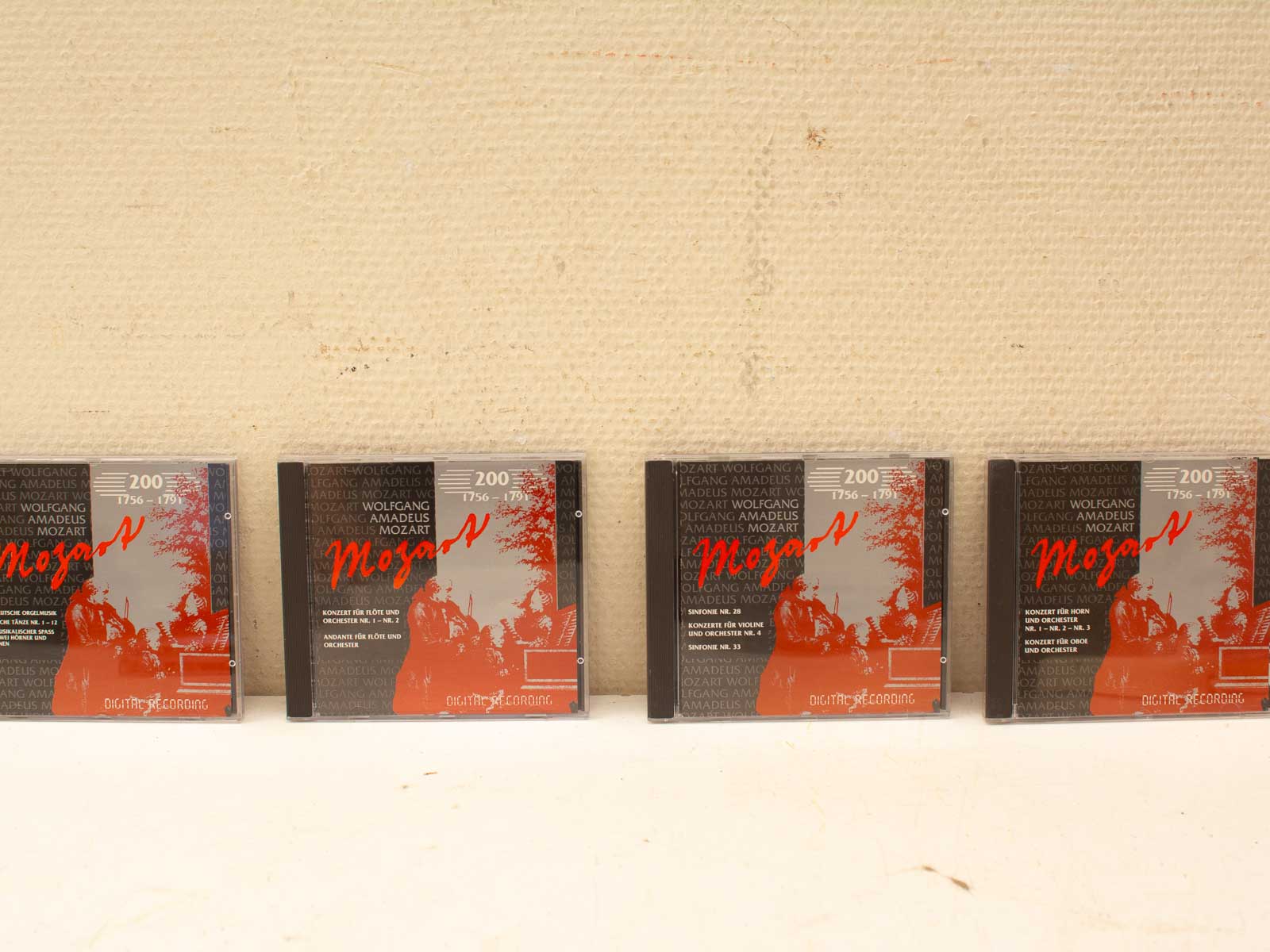 CD-collectie van Mozart met donkere ontwerpen en opvallende rode titels, tweedehands.