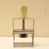 Vintage date stamp with a sturdy metal frame and adjustable wheels for easy date printing.
