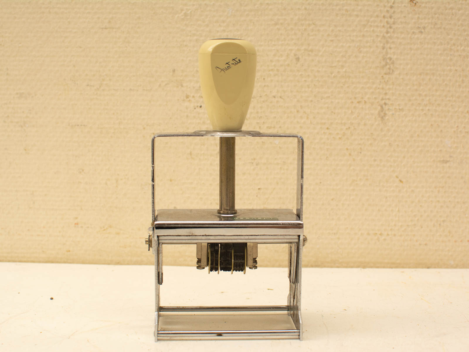 Vintage date stamp with a sturdy metal frame and adjustable wheels for easy date printing.