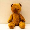 Charming vintage teddy bear, a soft companion with a loving history and playful expression.