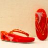 Vibrant red geta with golden accents, perfect for festivals and special occasions.