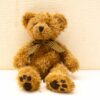 Charming teddy bear with a vintage bow tie, perfect for cuddling and nostalgic comfort.