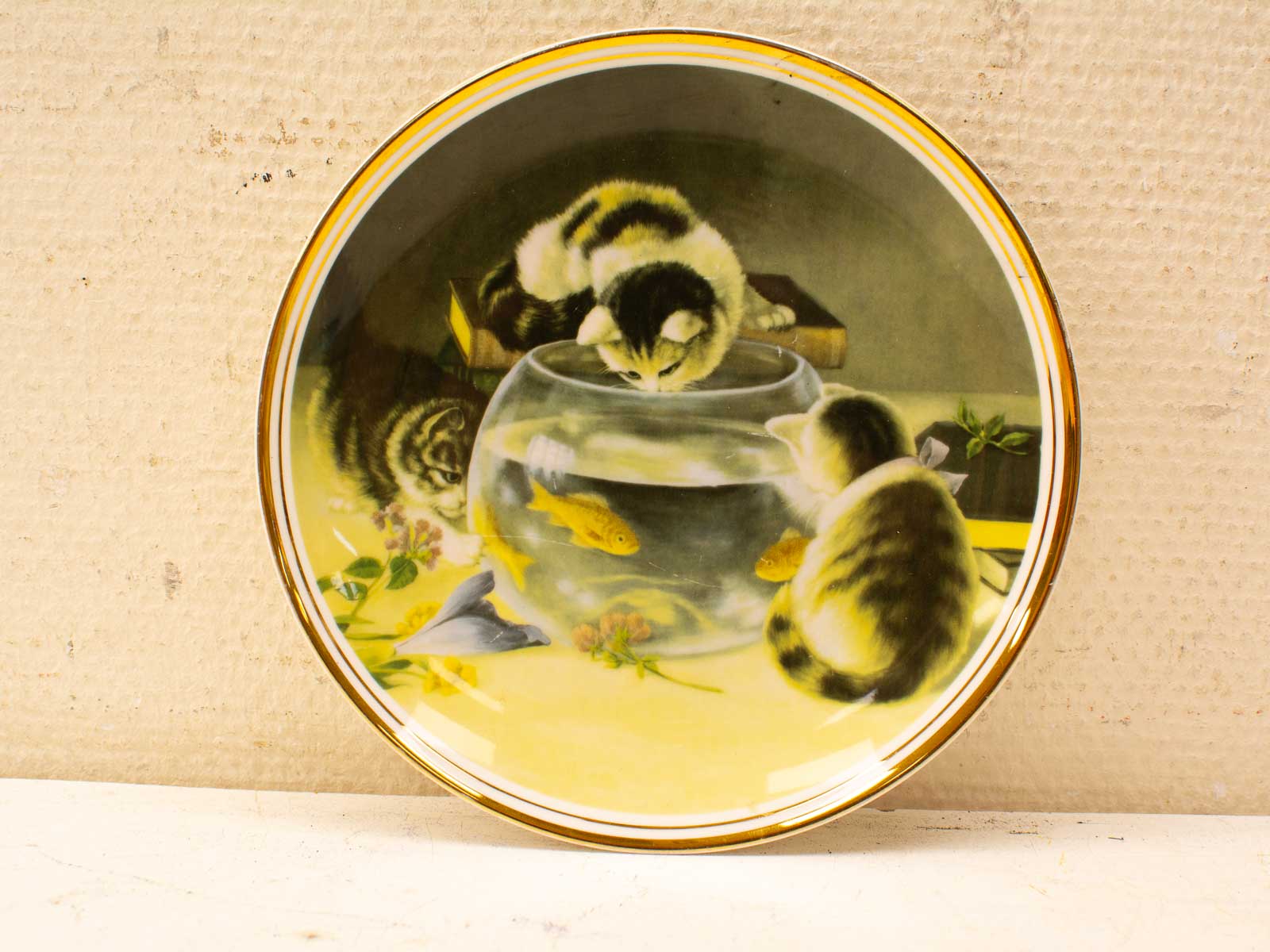 Charming porcelain plate featuring playful cats and a fishbowl with goldfish, perfect for collectors.