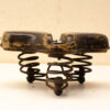 Vintage leather bicycle seat with springs, showcasing wear and unique character for collectors.
