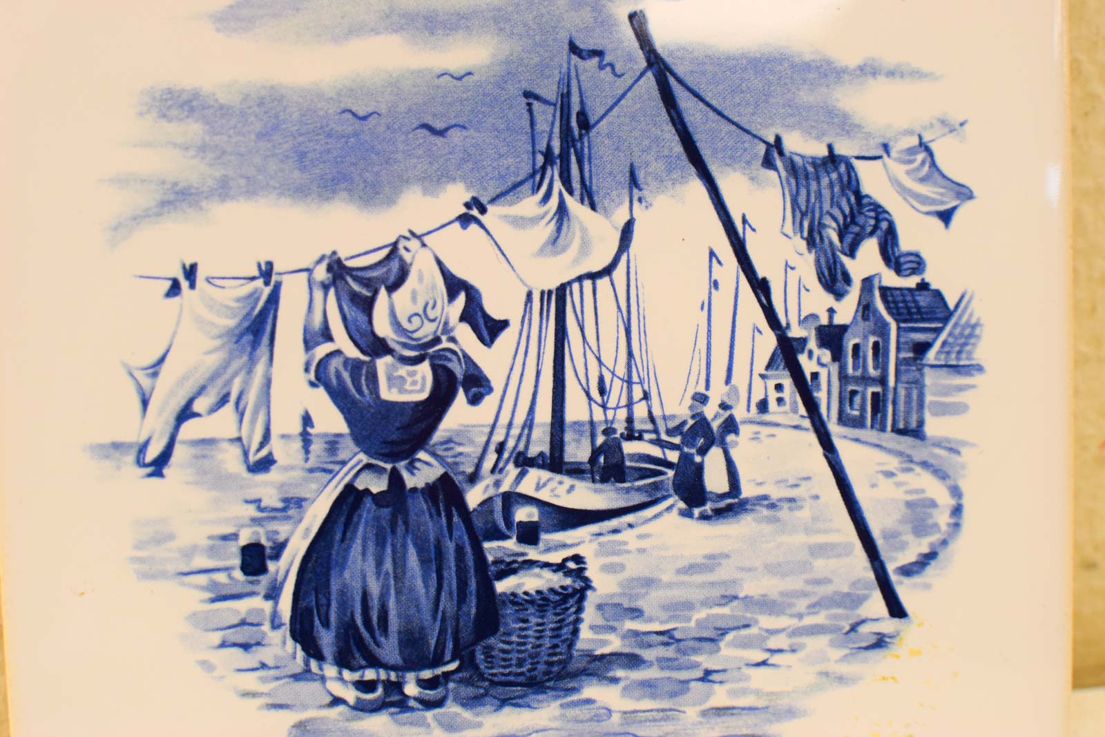 Alternative view of Wandtegel met prent van een vrouw die de was ophangt  47992