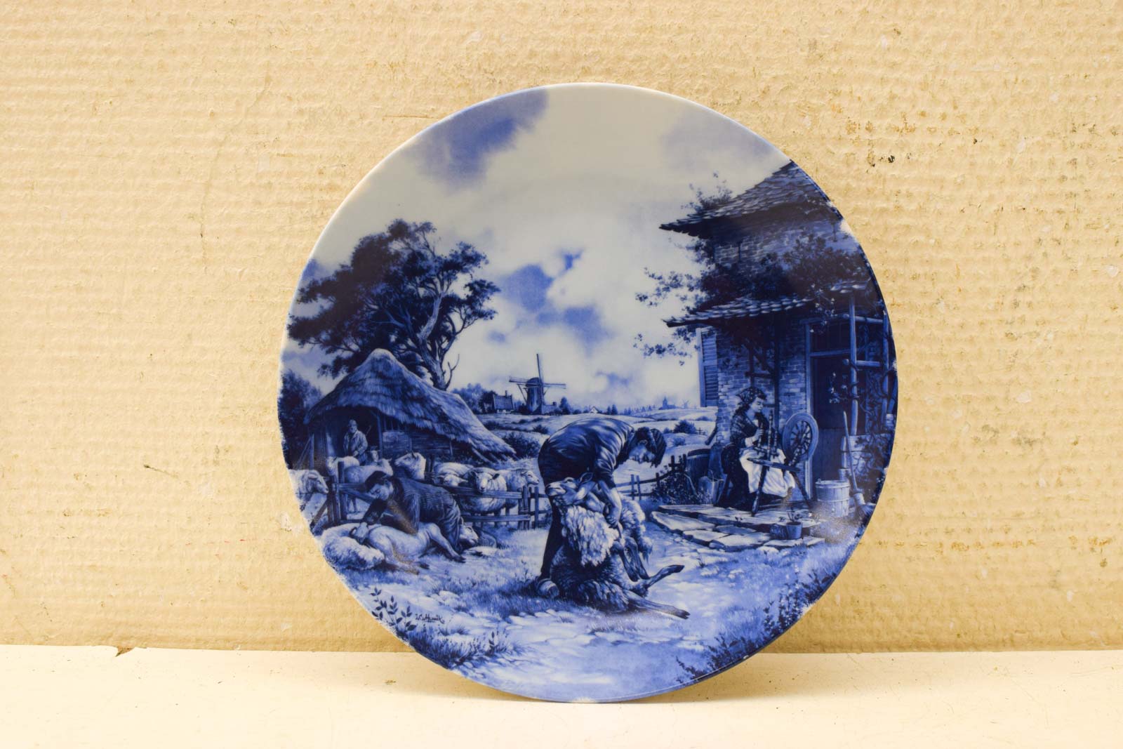 Delft Blauw porseleinen wandbord met prent van een man die schapen scheert  49005