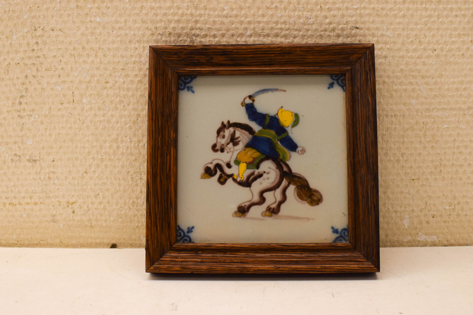 Wandtegel in houten lijstje een ridder op zijn paard 49769