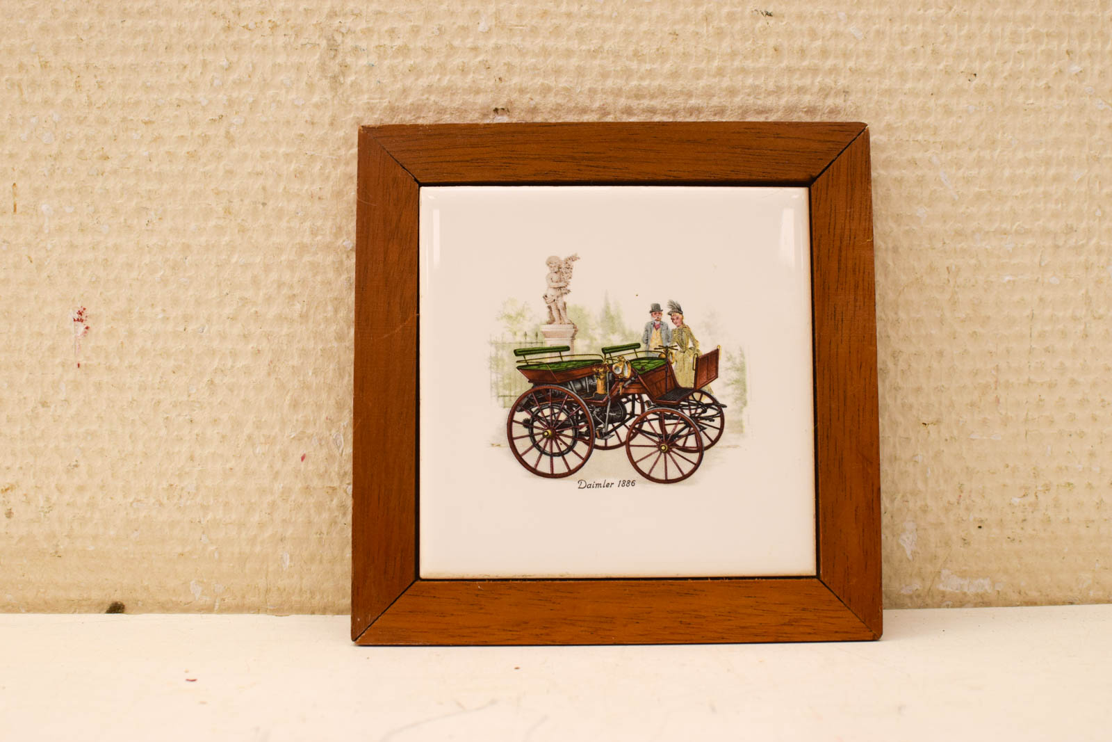 Wandtegel in houten lijstje met prent van een stelletje bij een koets  49836