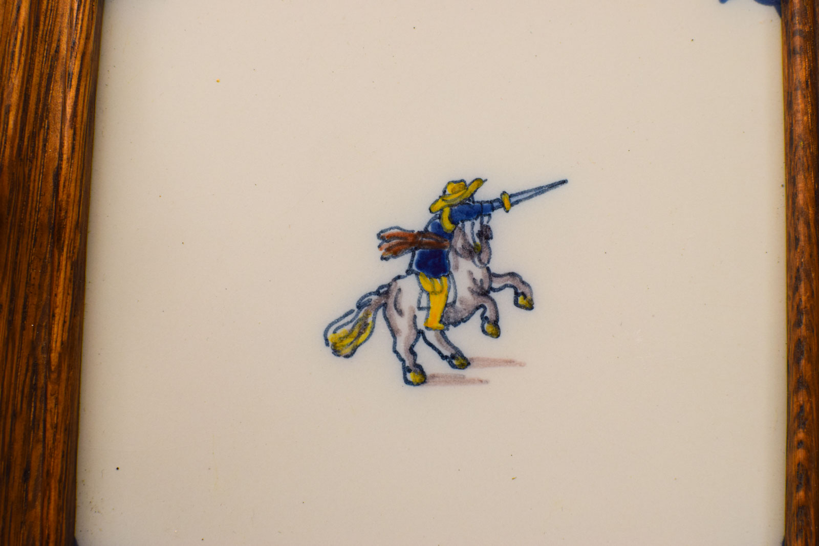 Alternative view of Wandtegel in houten lijstje met prent van een man met zijn zwaard op zijn paard  50599