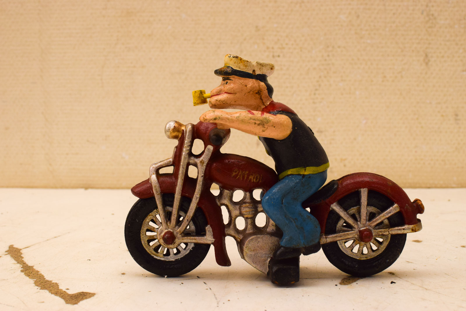 Gietijzeren beeld van Popeye op een motor 51197